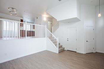 A white room with a staircase and two doors.